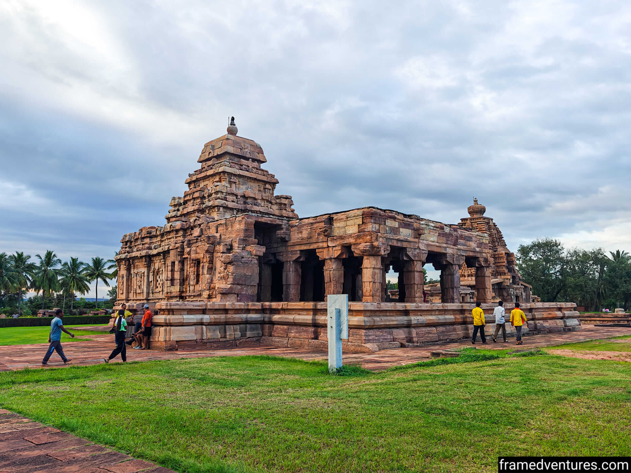 People walking next to a temple at Pattadakal